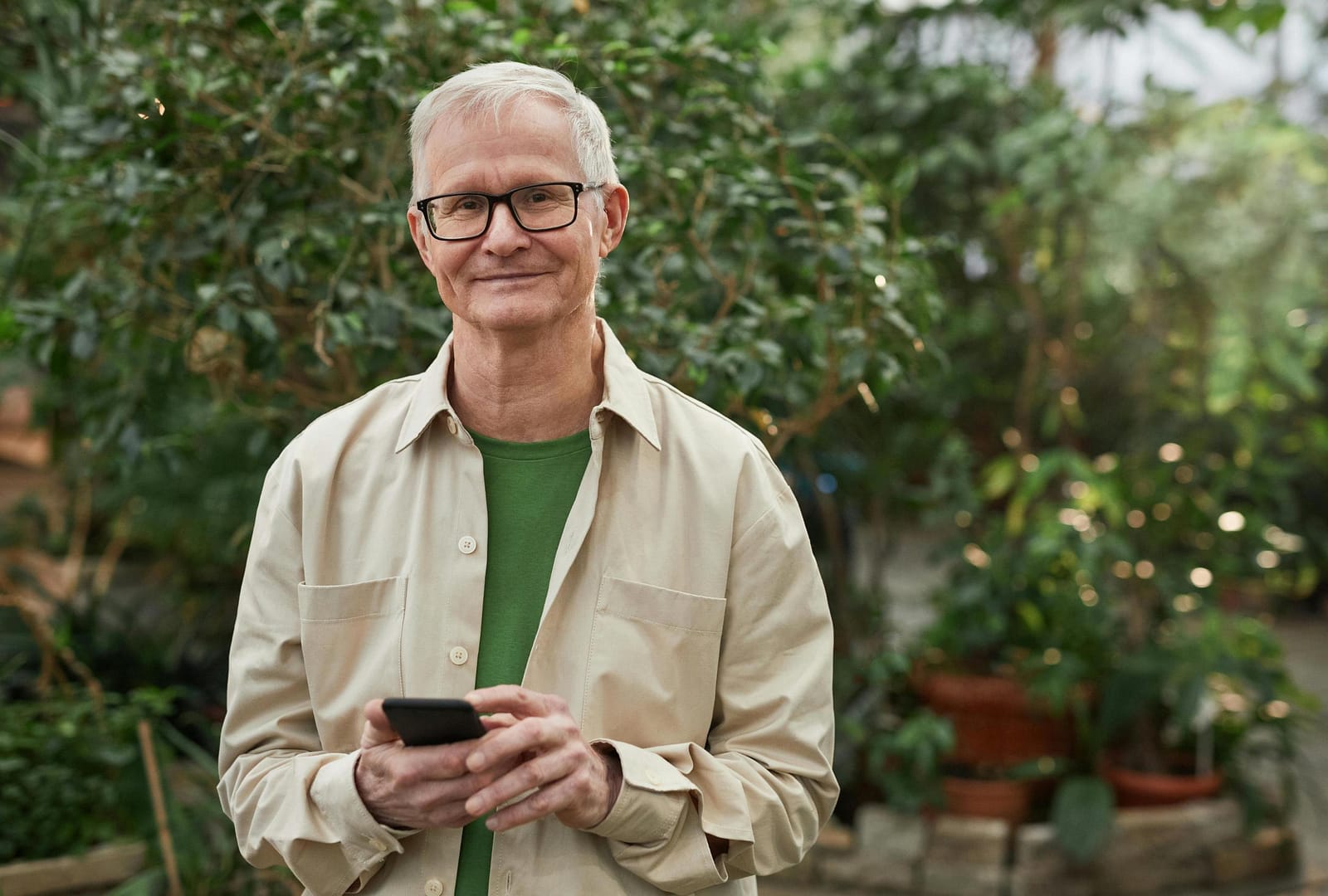Smiling older man holding smartphone