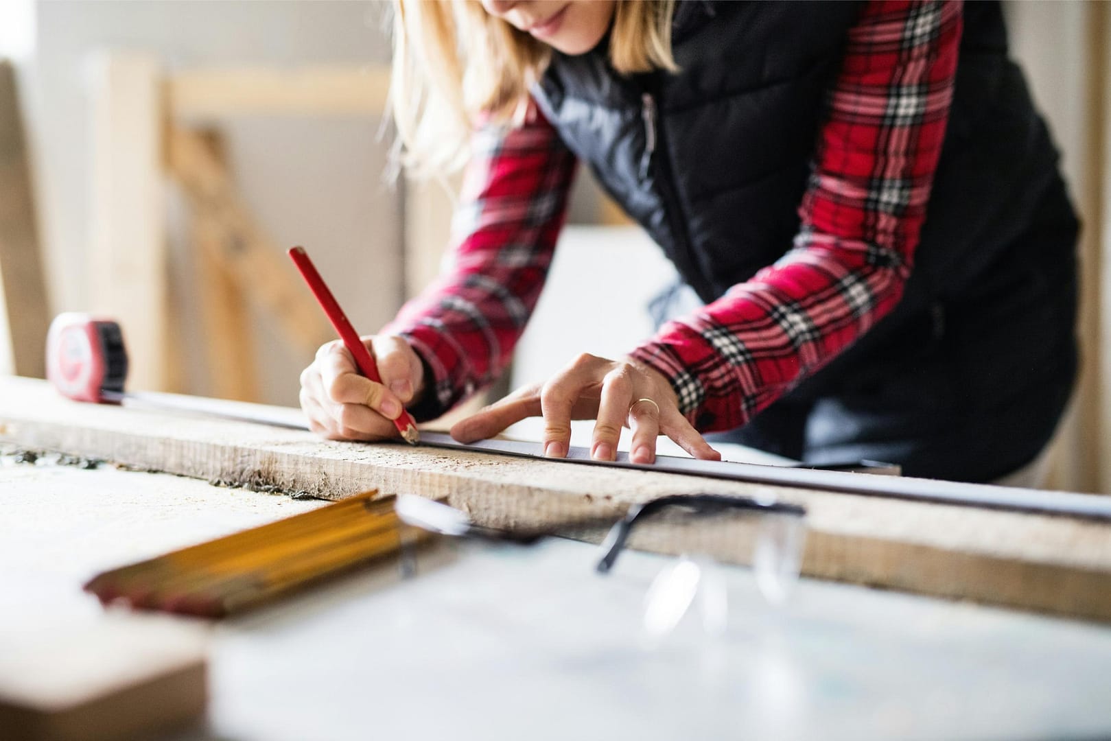 Handywoman measuring board length during remodel