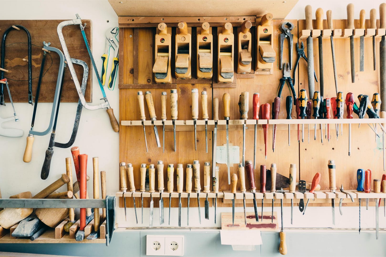 Carpenter and woodworking chisels and tools hanging on wall in wood shop