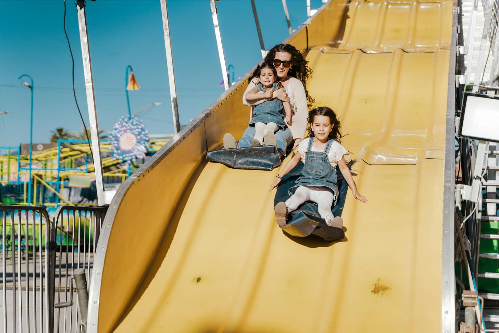 Family sliding down large slide at amusement park