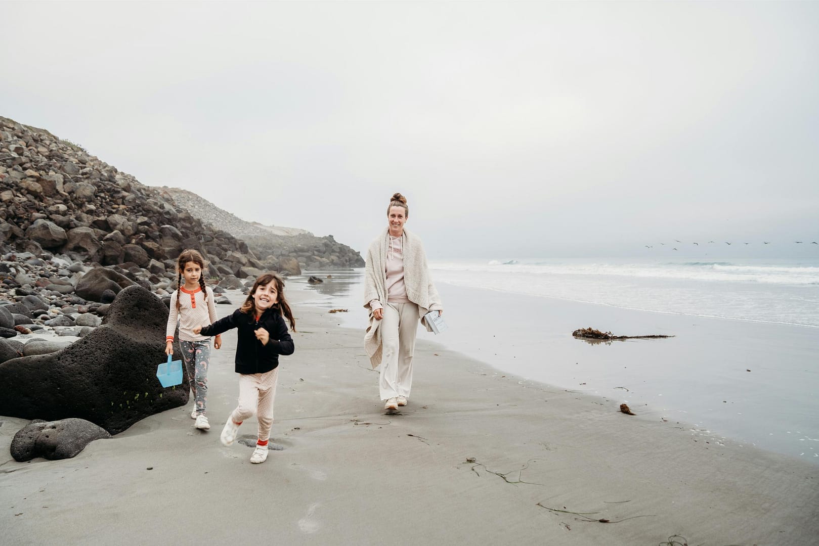 Mom walking with daughters on the beach