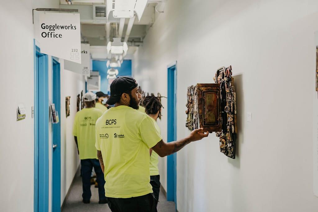 man interacting with art on the wall