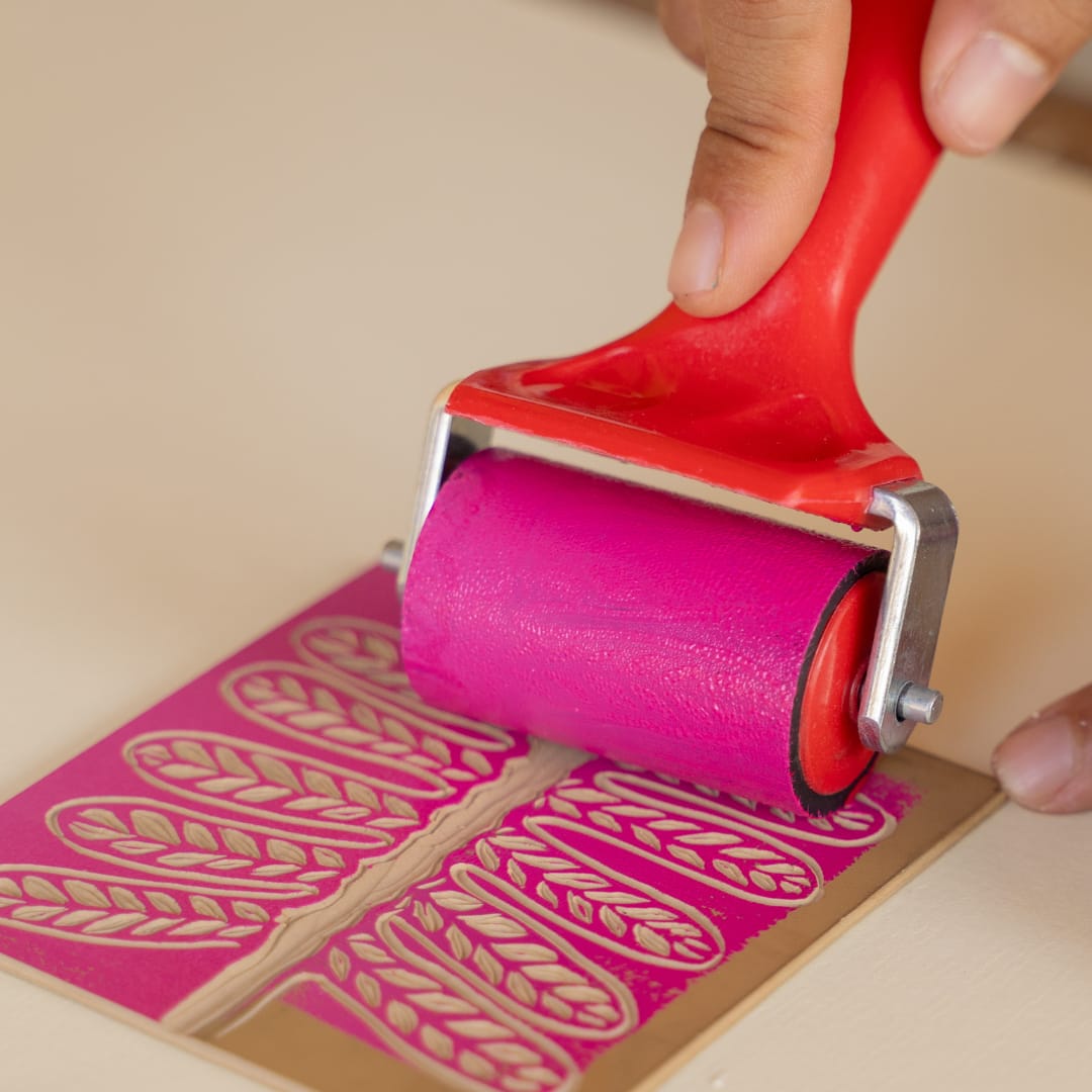roller applying hot pink ink to pattern