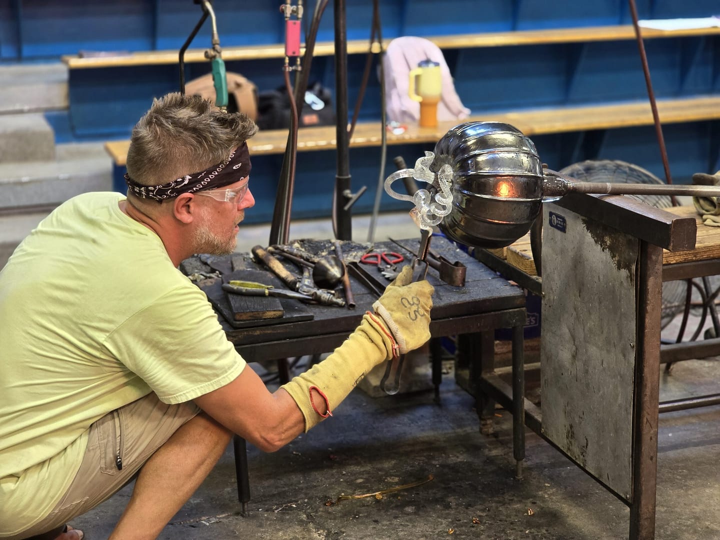 man adding glass to art piece