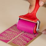 roller applying hot pink ink to pattern