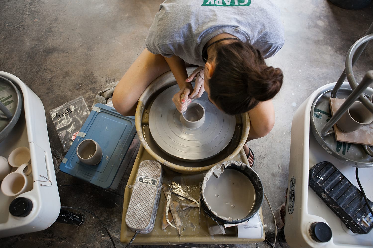 Woman on pottery wheel in GoggleWorks ceramics studio