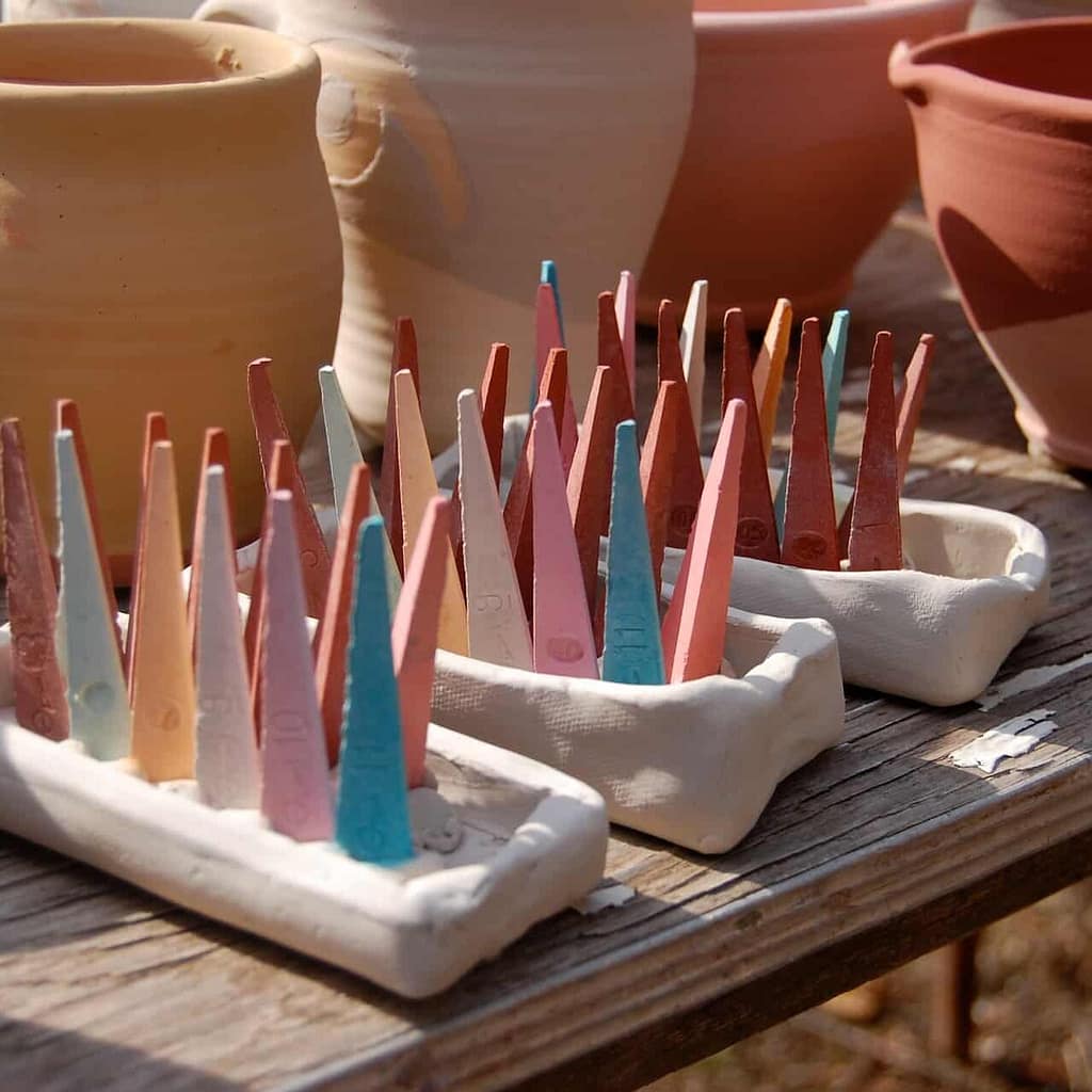 Ceramic Pottery made by community artists waiting to be loaded into the wood fired ceramic kiln. In the front there are pyrometric cones used to tell temperature