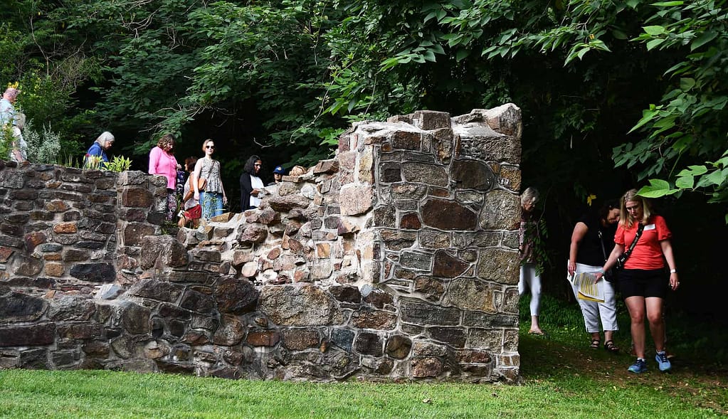 A tours group visits the preserved ruins of the revolutionary war hospital at the historic village on the national register of historic places.