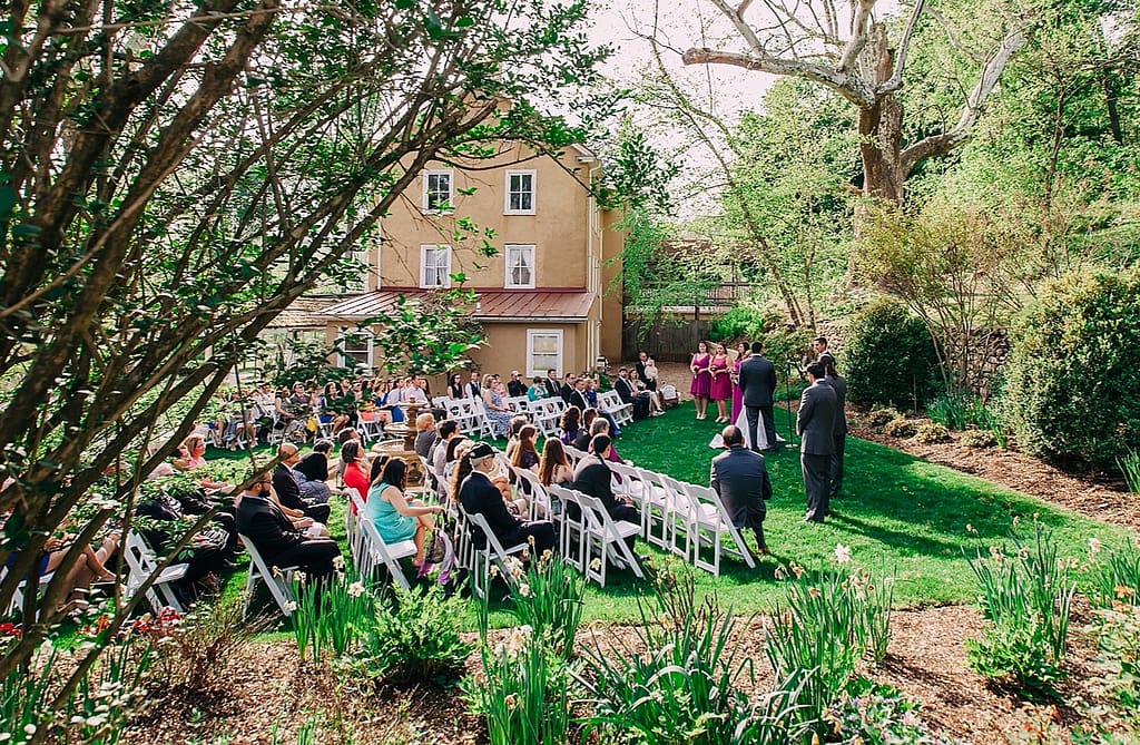 A wedding party shares a moment in the courtyard garden event space in front of the Washington venue at Yellow Springs.