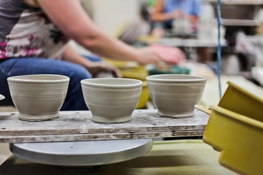 Students practice making pottery on the potter's wheel as part of the community classes with ceramic clay.