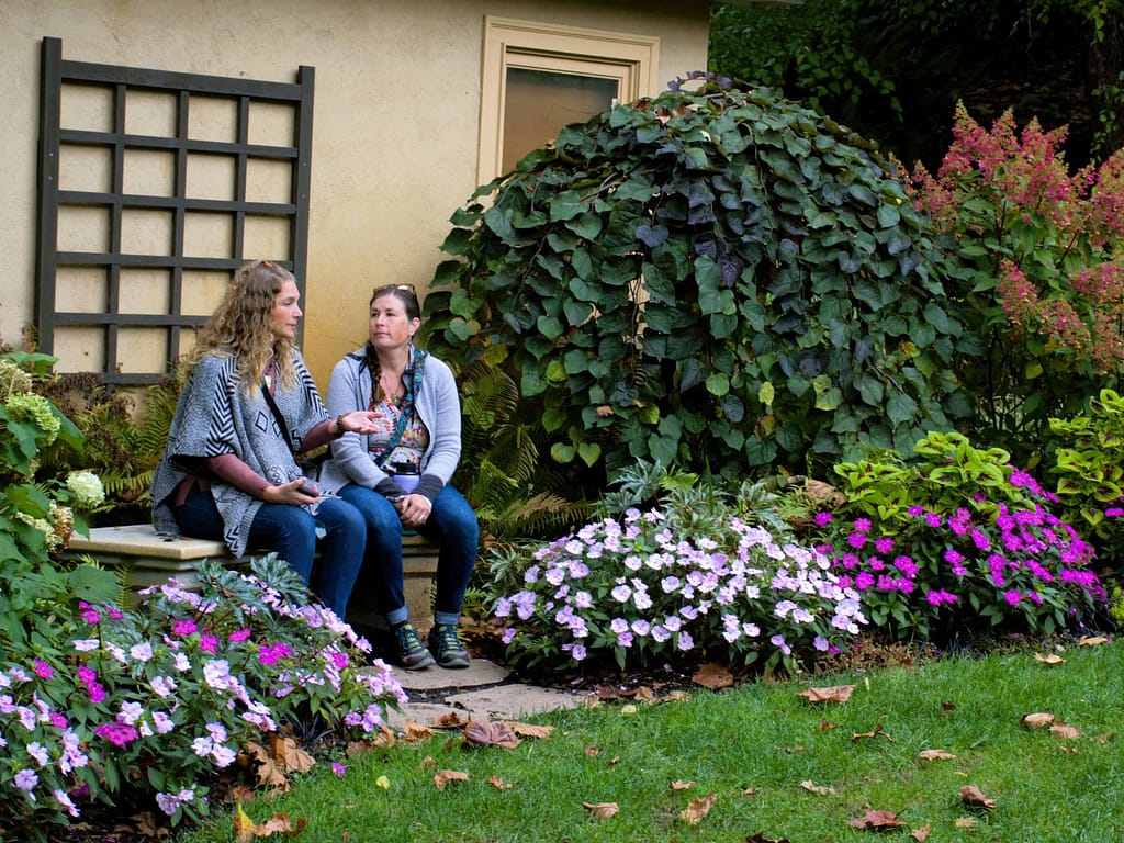 Community visitors talk while sitting at the wedding event space in the courtyard gardens at the historic Washington building