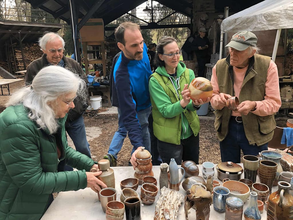 Students unload the woodfired ceramics kiln as part of a visiting artist pottery class