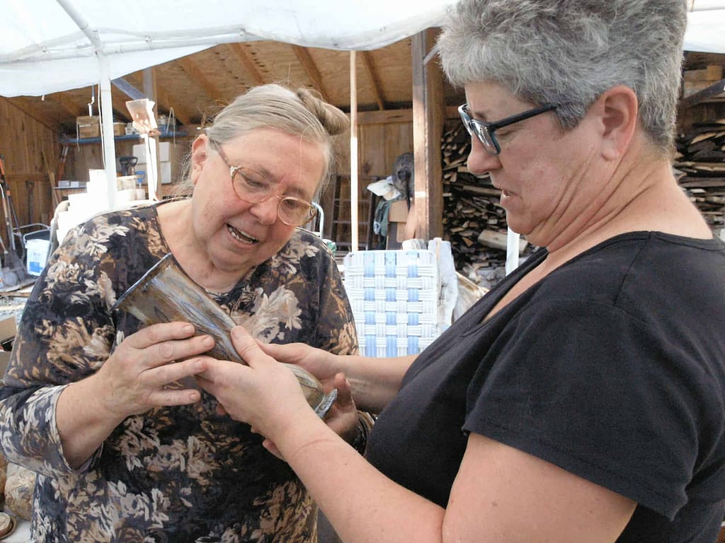 Students unload the woodfired ceramics kiln as part of a pottery class