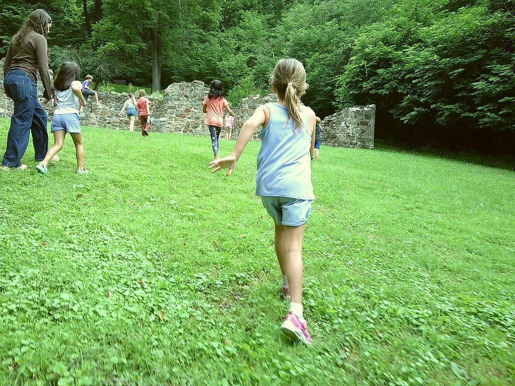 Youth summer camps students run among the historic ruins in nature.