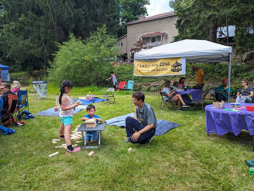 Children plan in the family zone while celebrating history and the environment in front of a preserved building.