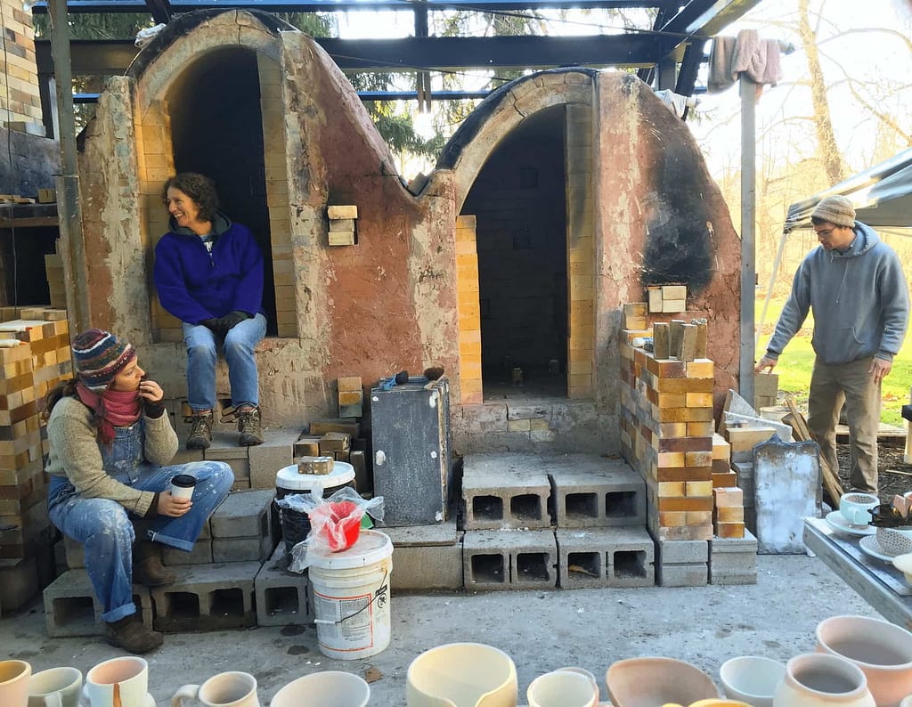 Students unload the woodfired ceramics kiln as part of a pottery class