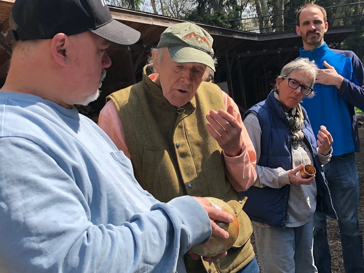 Visiting artist works with woodfire students to explain why pottery pieces came out of the ceramic kiln a certain way.