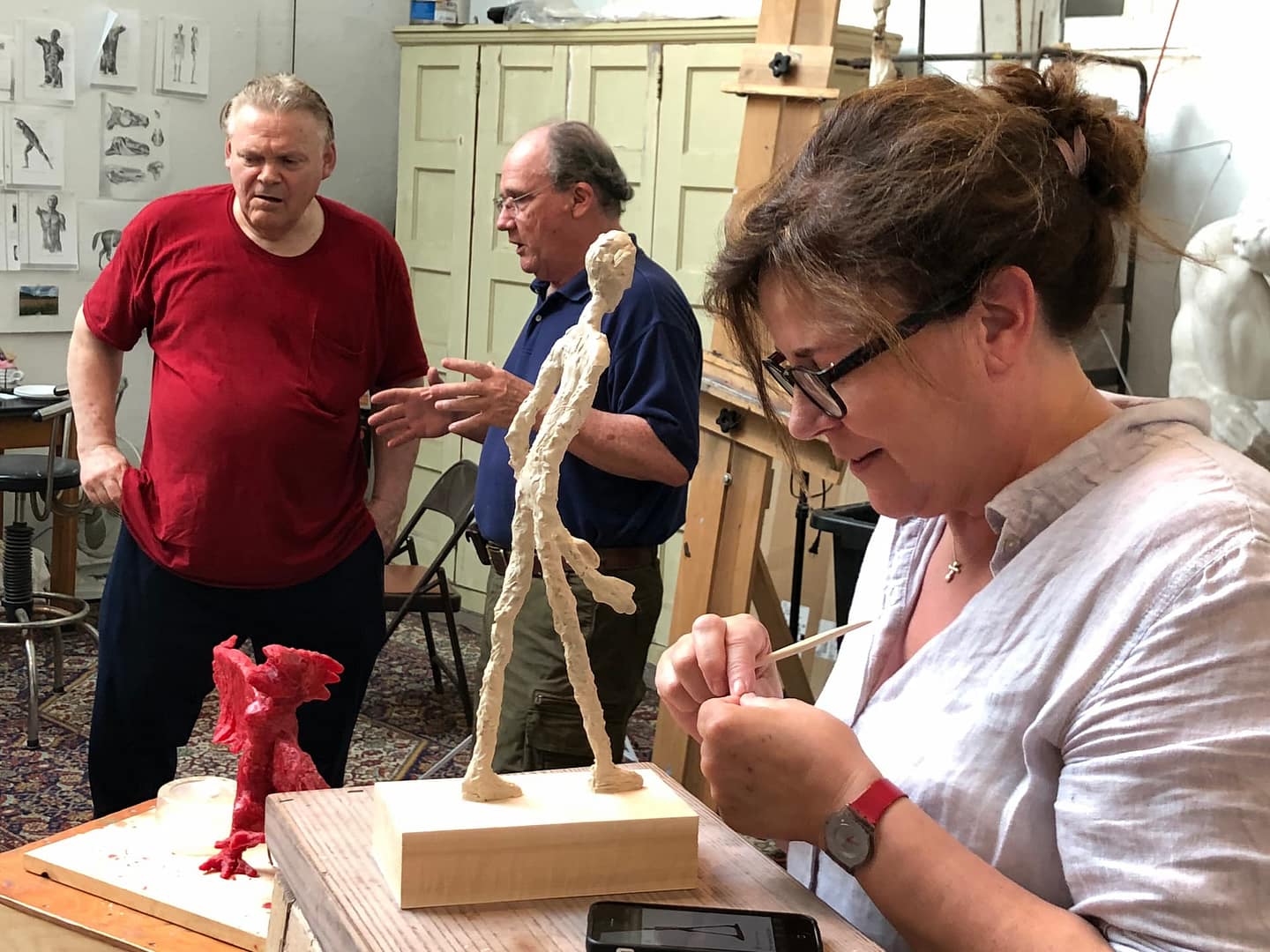 Adult art students work in a class focused on sculpting with ceramics