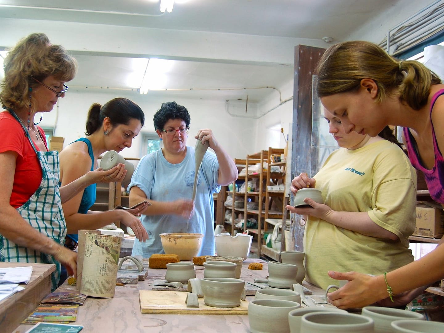Ceramics students work together in community to finish pottery artworks