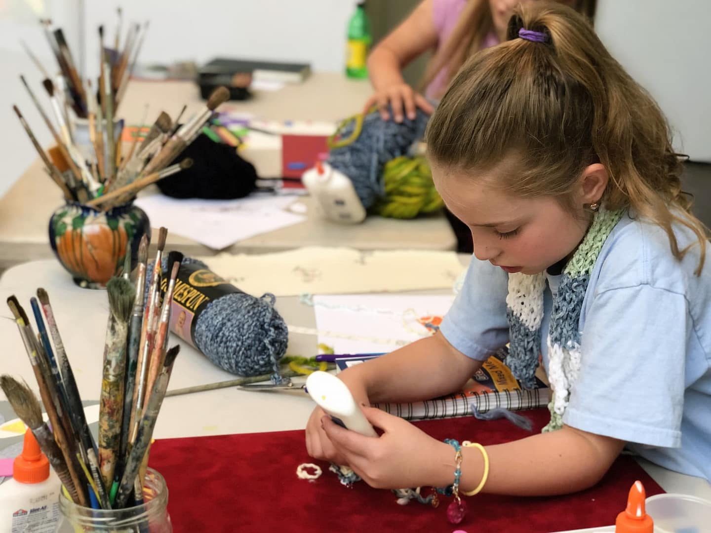 Youth students work at a camp to make paintings out of fabric based on original drawings
