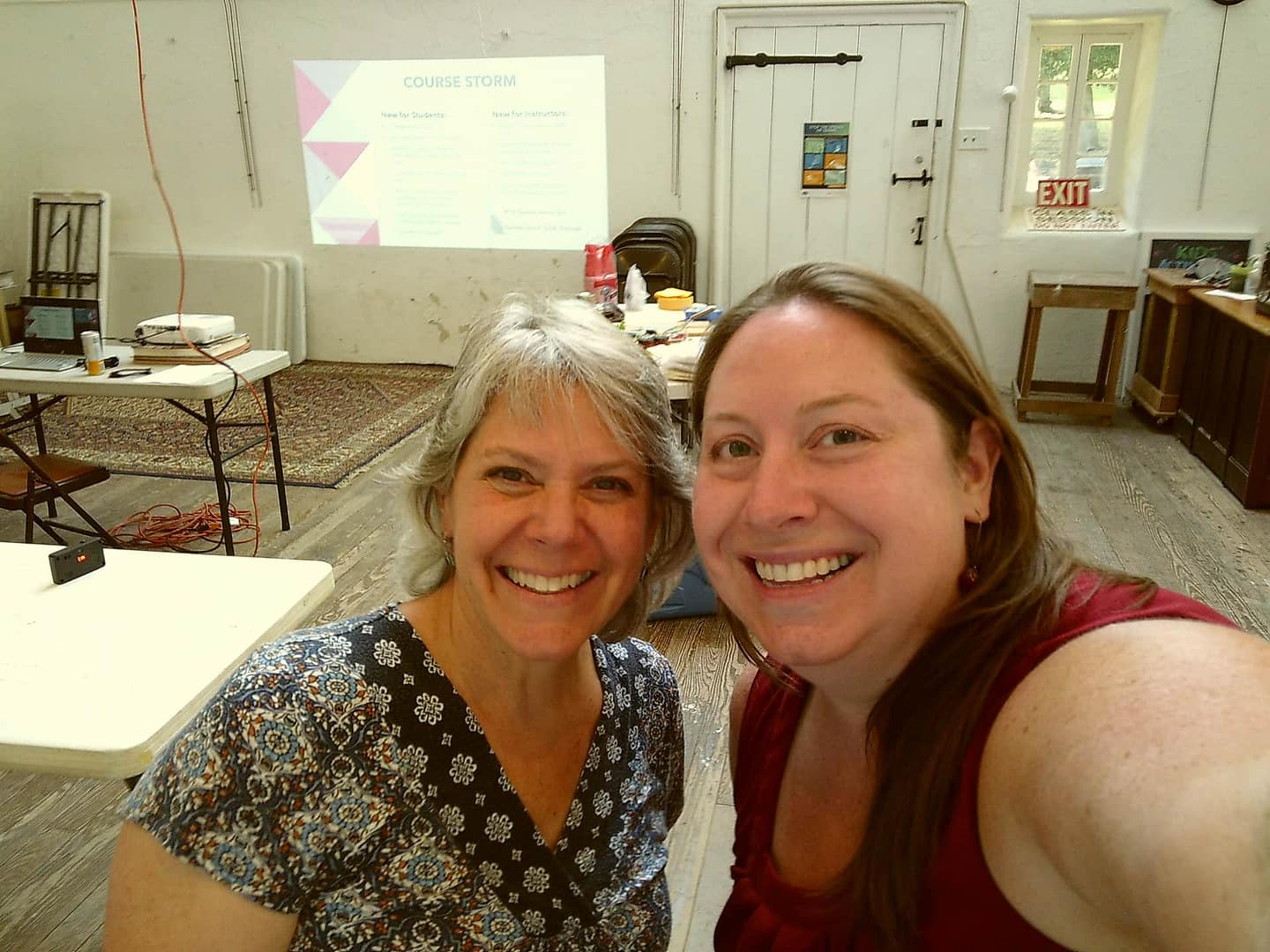 Two ceramics teachers pose for the camera in the painting studio.