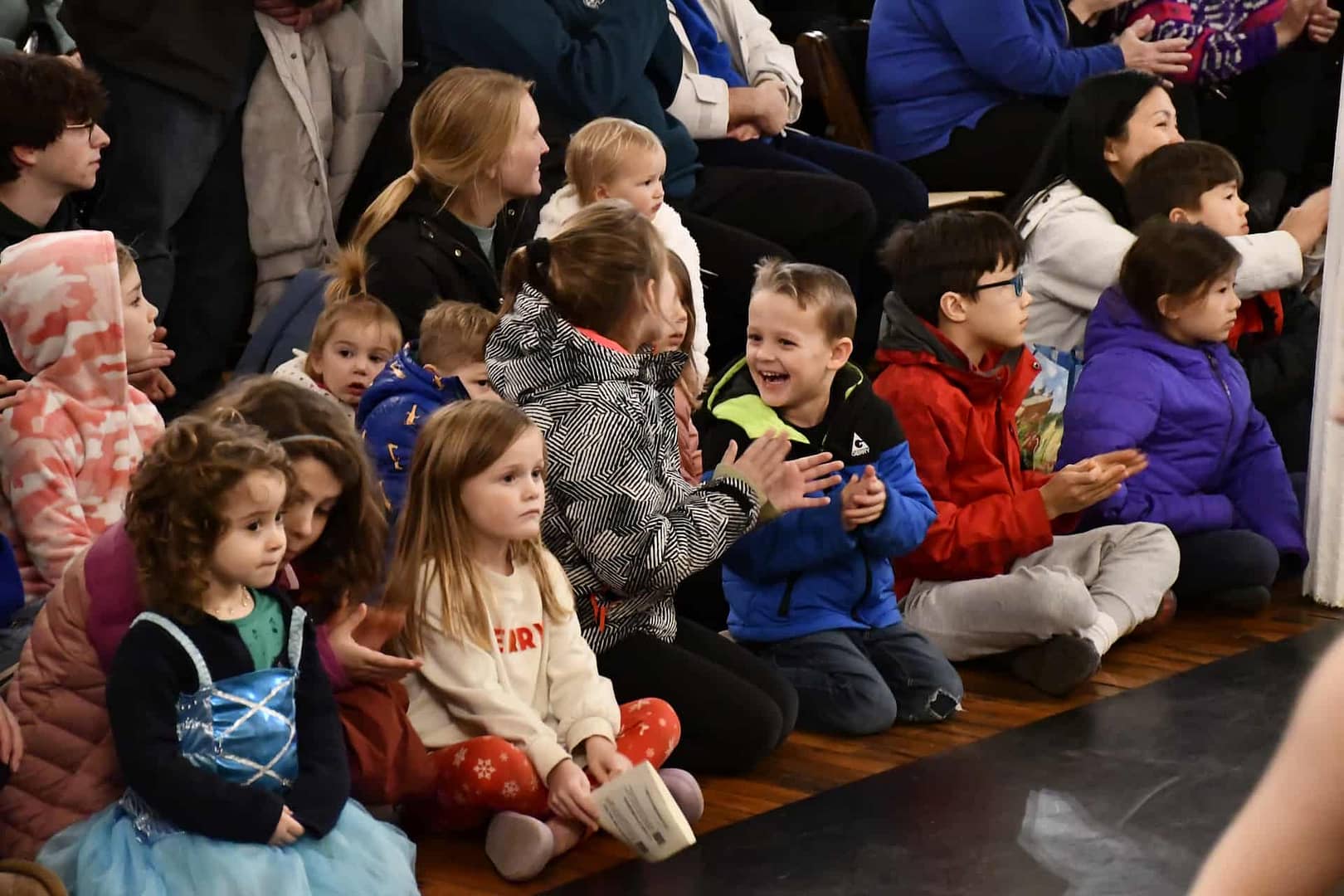 Children cheer between performances at the winter holiday event in the village that is on the National Register of Historic Places