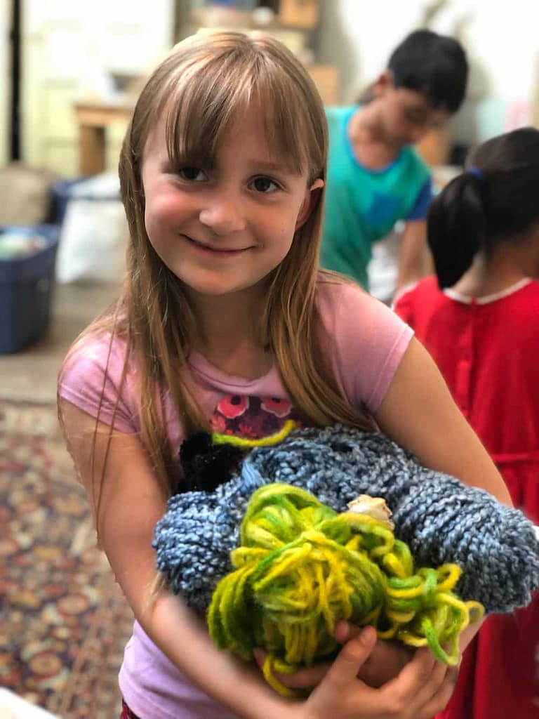 Youth students work on a textile activity while participating in a camp program and class