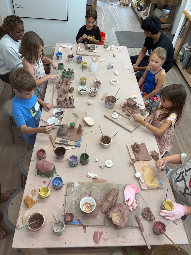 Campers are shown working around a table doing a clay project at Yellow Springs Youth Summer Camp.