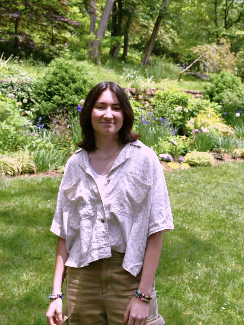 A staff member posing in the preserved gardens at historic yellow springs