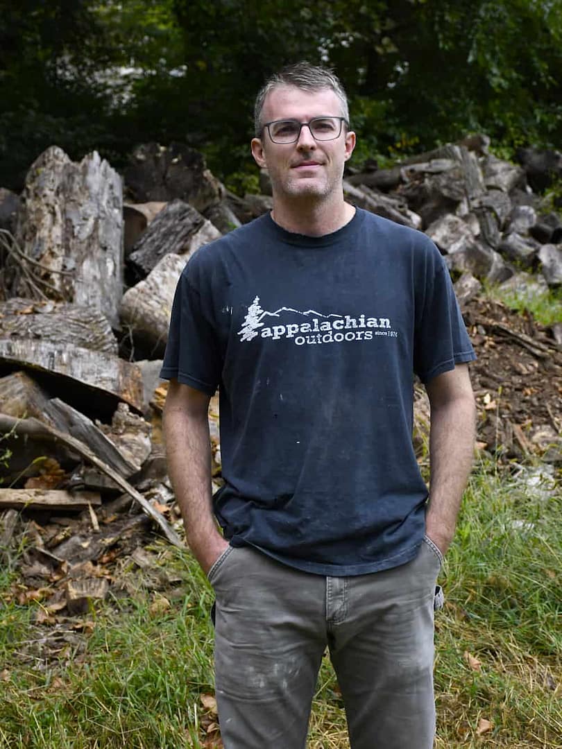 A staff member posing in the pottery and ceramics wood preparation area at historic yellow springs
