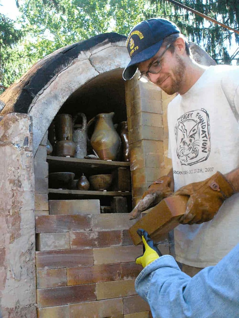 Students unload the woodfired ceramics kiln as part of a pottery class