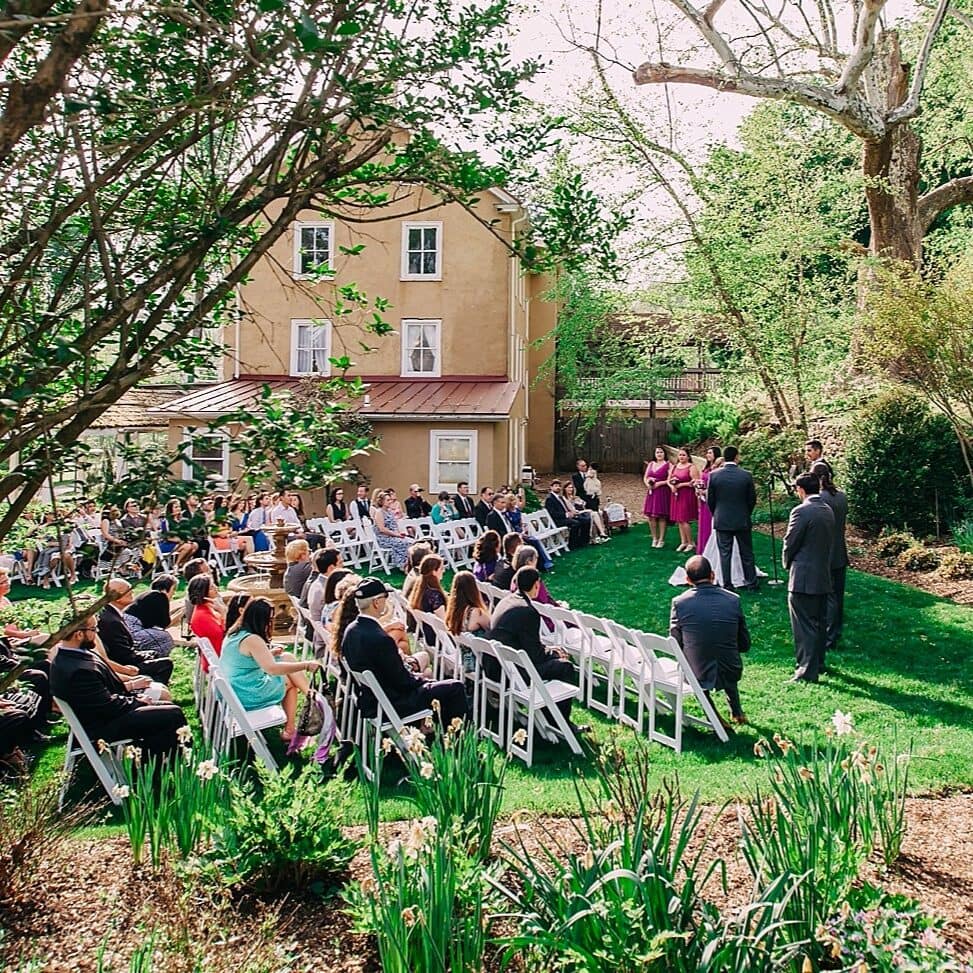A wedding party shares a moment in the courtyard garden event space in front of the Washington venue at Yellow Springs.