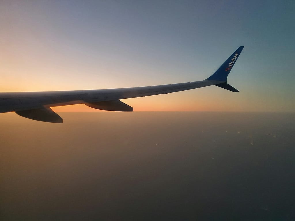 the wing of an airplane as the sun sets